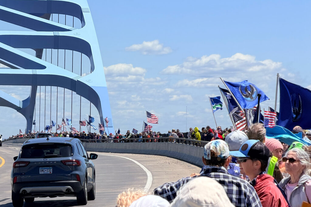 Picture of a protest with people lining the bong bridge between Duluth MN and Superior WI - protesting Donald Trump on his 80th Birthday